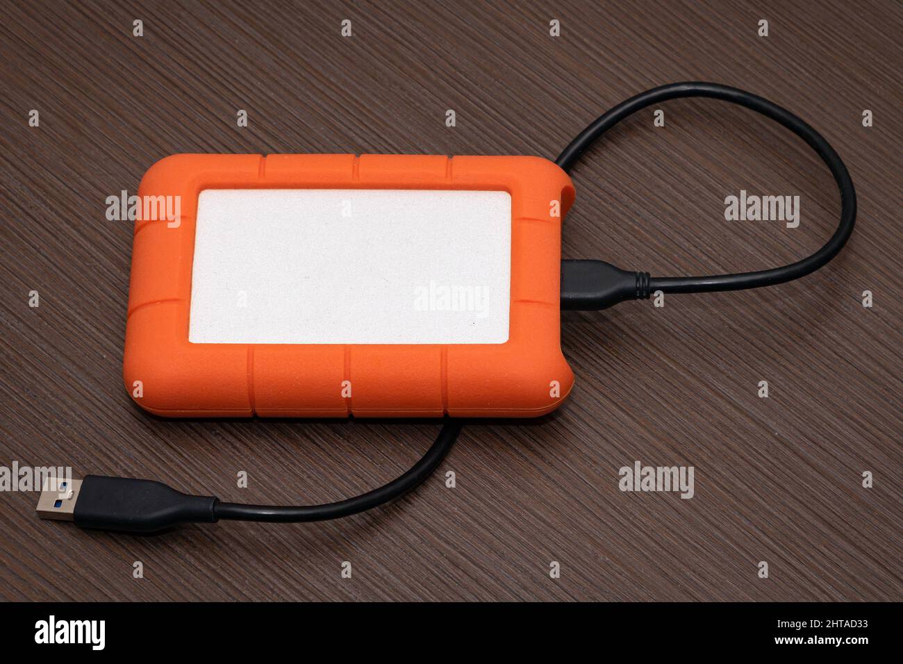 Modern technology computer hard drive with USB connection cable on wooden table Stock Photo