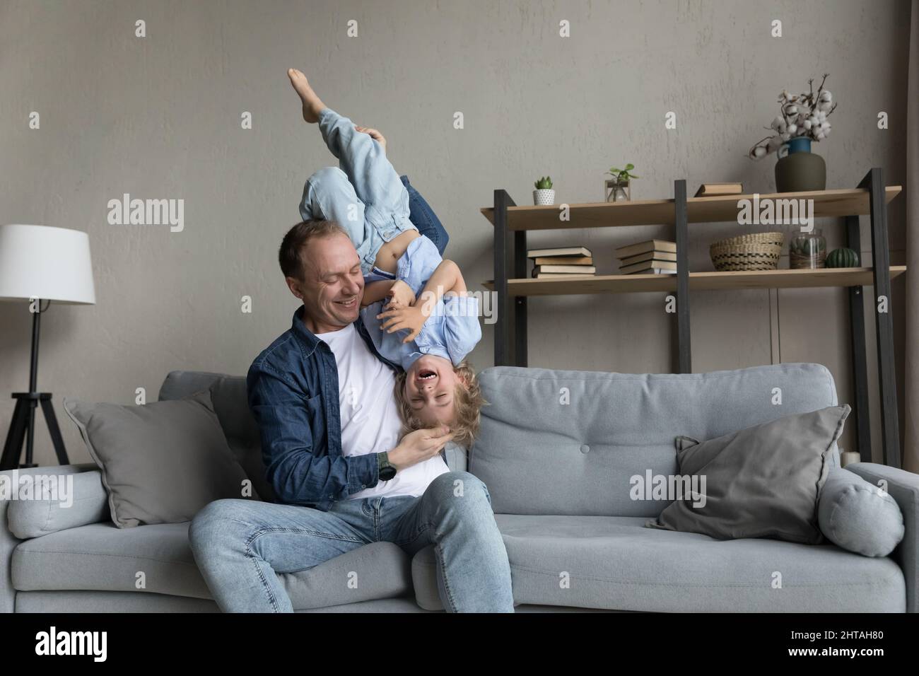 Happy cheerful dad holding excited funny preschool son kid Stock Photo