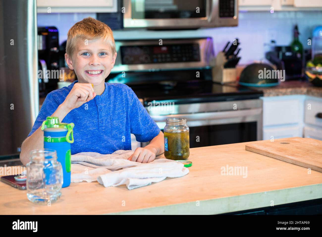 Little boy eating salted cucumbers Stock Photo