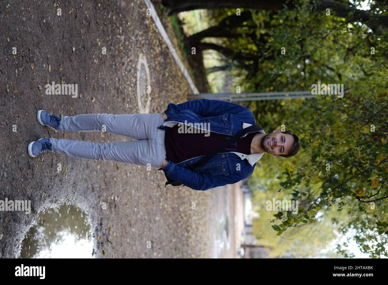 Cheerful young White guy in a park dressed casually Stock Photo