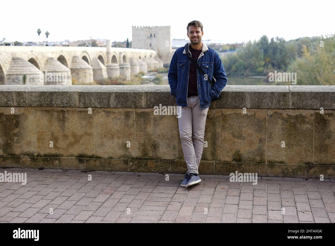Cheerful young White guy posing on a bridge dressed casually Stock Photo