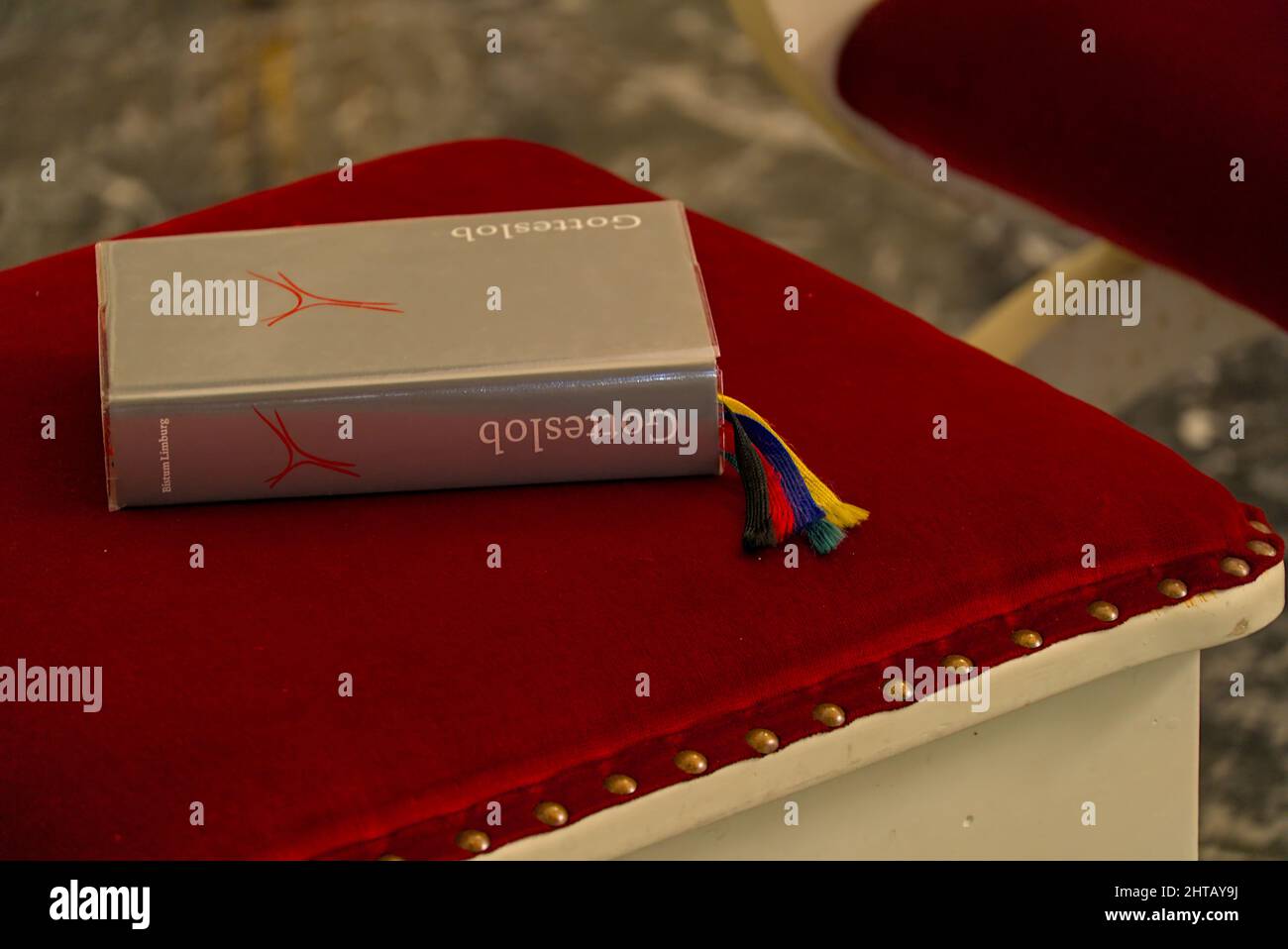 Holy bible on a red velvet covered chair Stock Photo Alamy