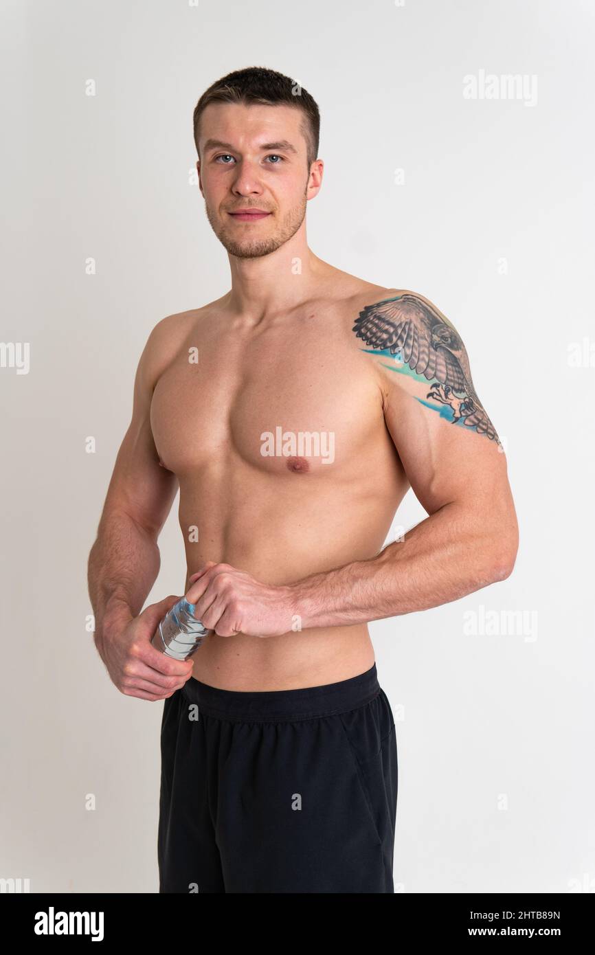 Male drink-water fitness is pumped with a towel on a white background isolated fitness muscular body, sport gym guy, Bodybuilding copy active Stock Photo