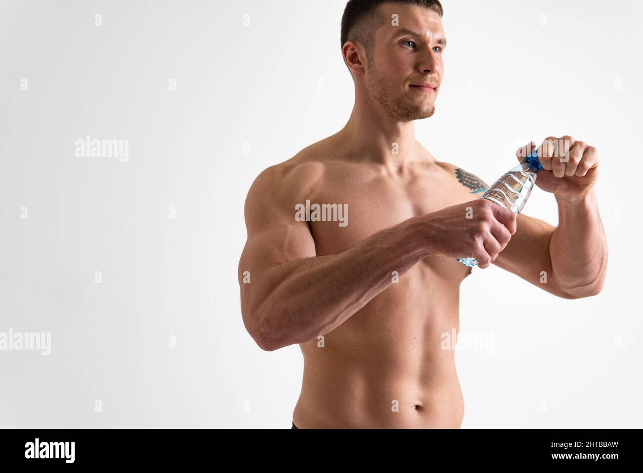 Male drink-water fitness is pumped with a towel on a white background isolated fit lifestyle, training exercise male holding, background cardio Stock Photo