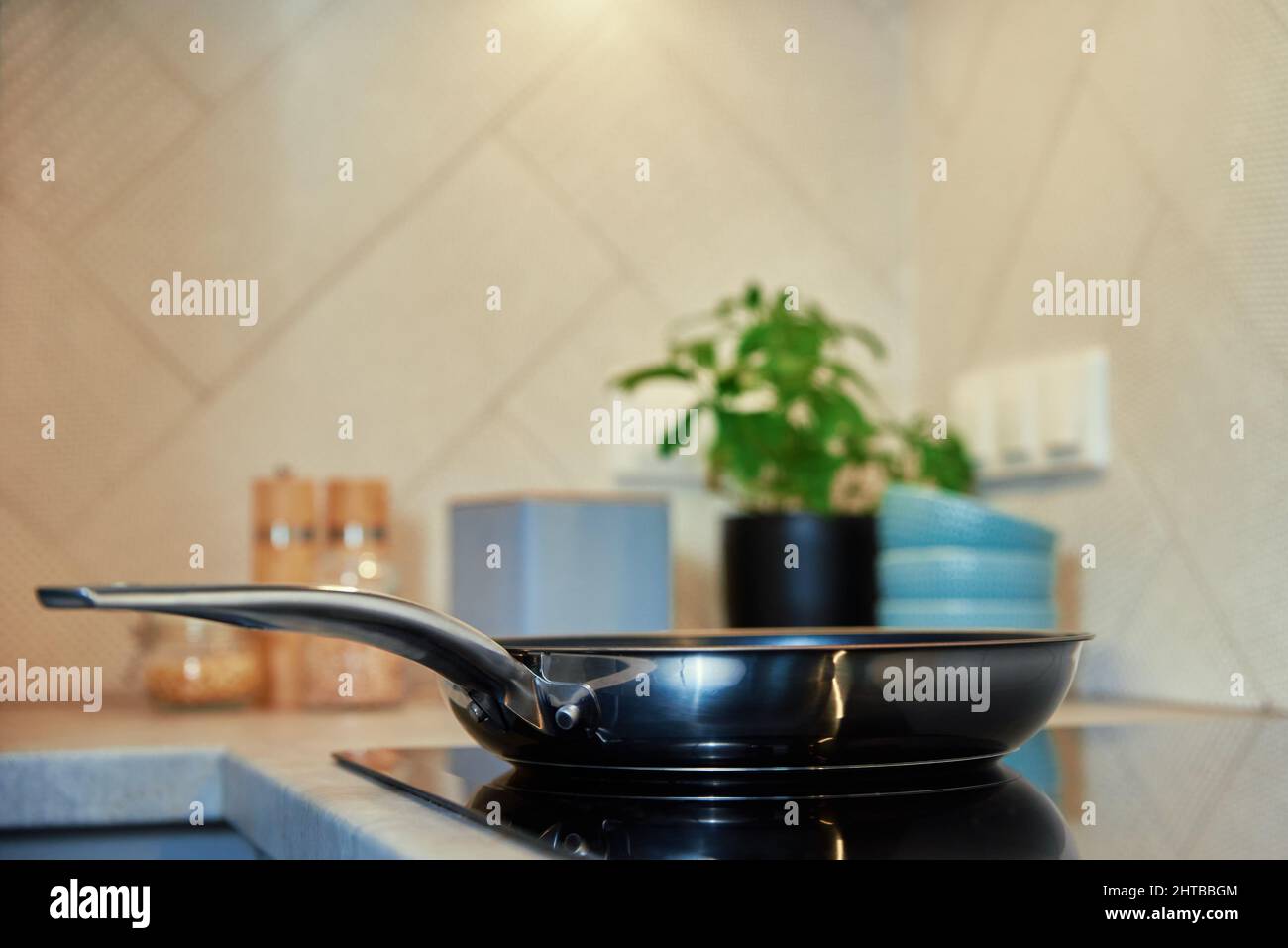 Steel frying pan in the kitchen on electric induction hob, Modern