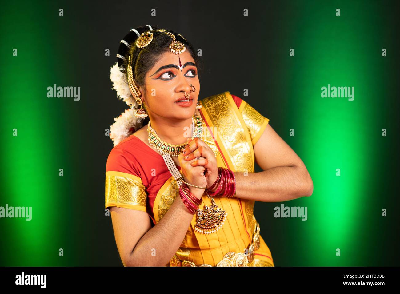 Young bharatnatyam dancer performing fearful or sorrow expression or emotion on stage - concept of indian culture, traditional and classical dance Stock Photo