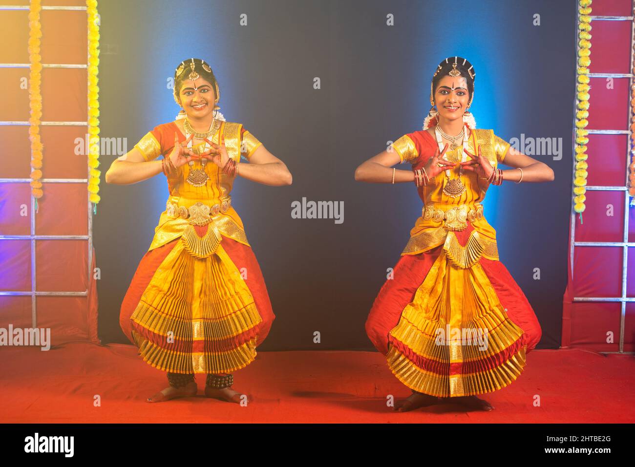 Traditional young bharathnatyam dancers performing on stage - concept of indian culture and professional classical dancers. Stock Photo