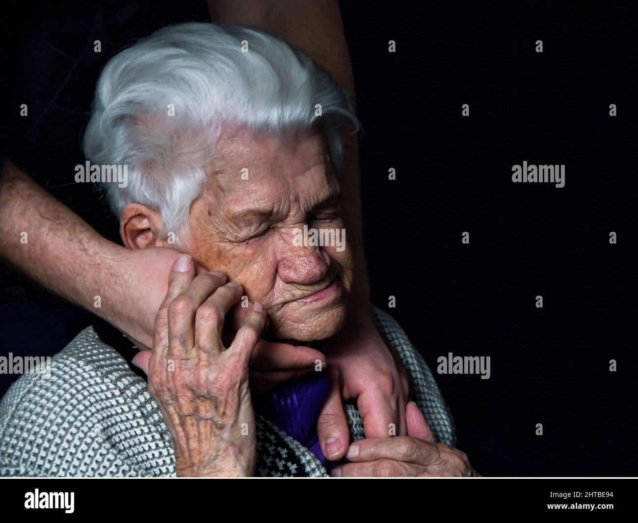Hands of an elderly woman against black background.  Stock Photo
