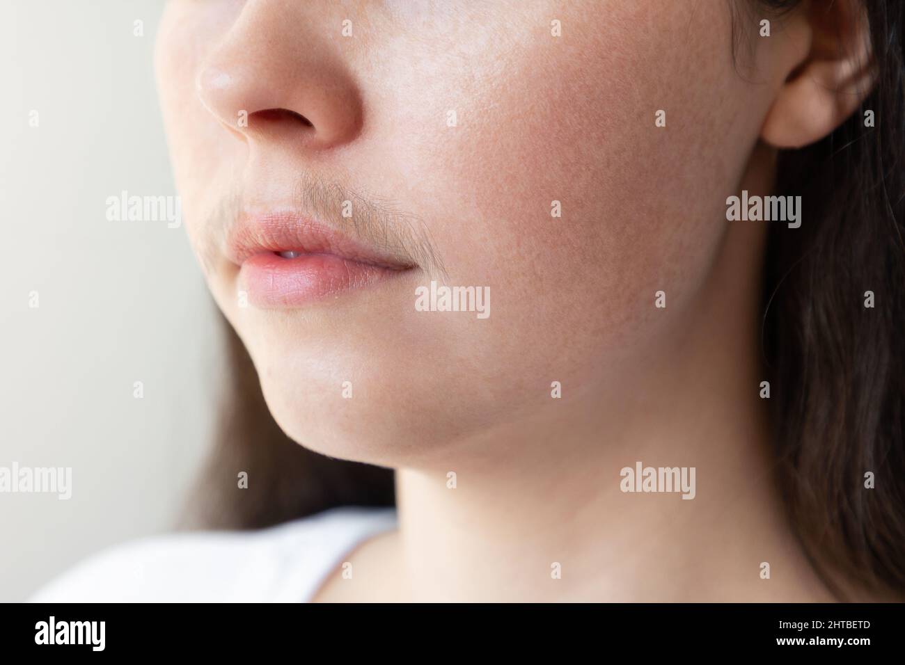 A close-up of a woman's face with a mustache over her upper lip. The concept of hair removal and epilation. Stock Photo
