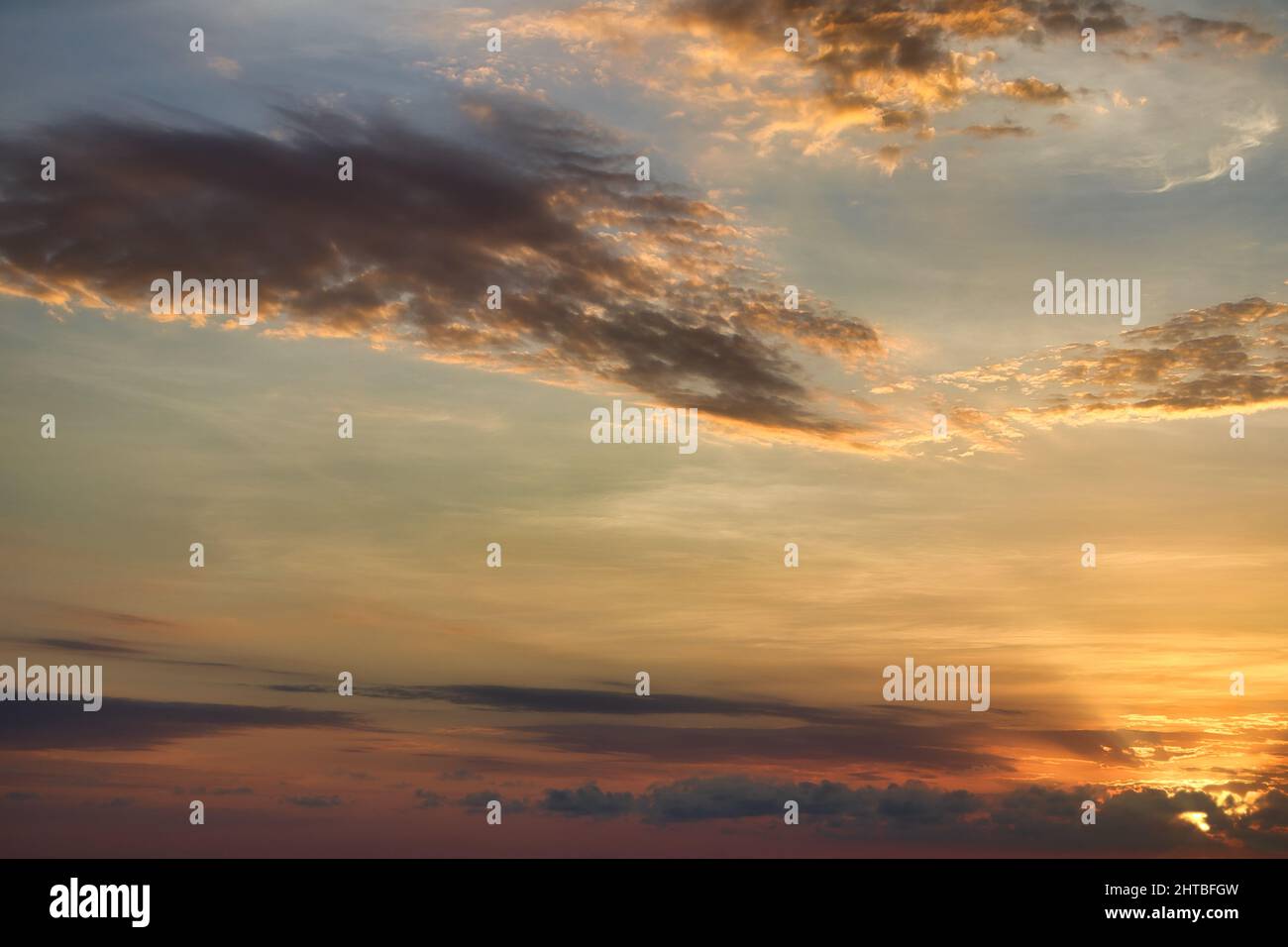 Scenic view of fluffy clouds changing colors at sunset Stock Photo