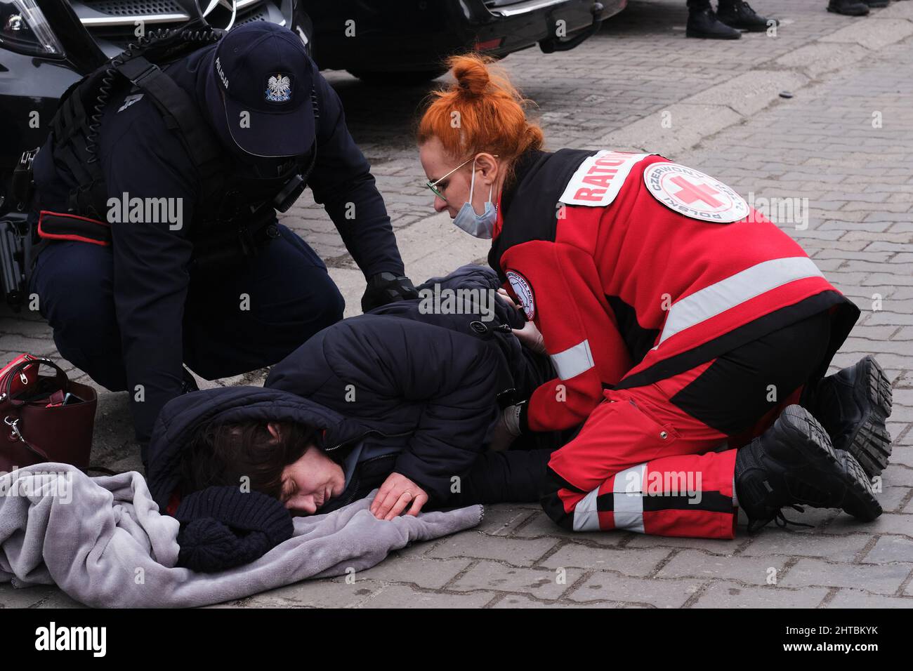 Przemysl, Poland. 27th Feb, 2022. A fainted woman receives help at the Przemysl railway station in Przemysl, Poland, Feb. 27, 2022. Recently, a large number of Ukrainian people arrived in Przemysl by train. Credit: Meng Dingbo/Xinhua/Alamy Live News Stock Photo