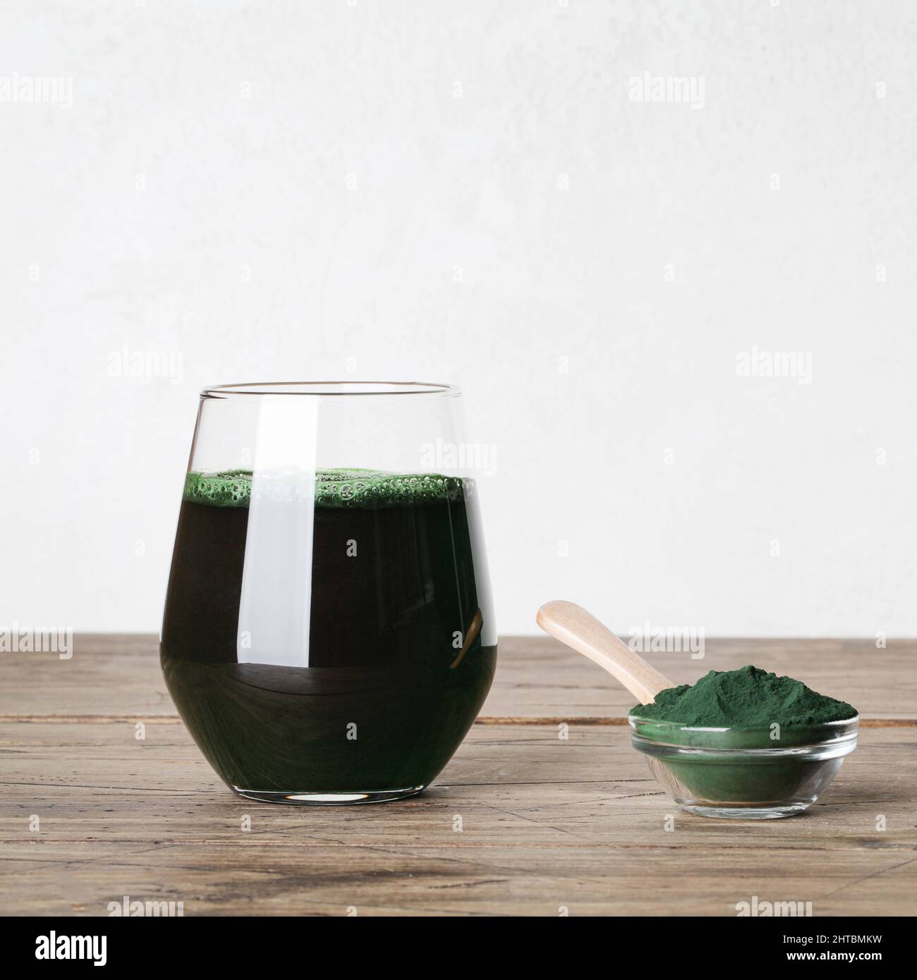 fresh green drink with spirulina in glass, spirulina powder with spoon