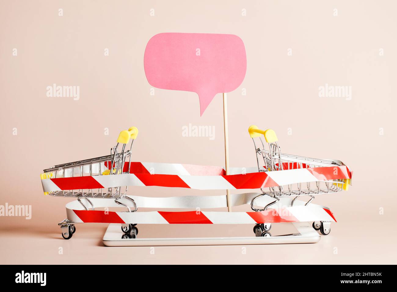 Shopping online and home delivery concept. shopping baskets wrapped with warning tape on tablet and blank paper for text. copy space.  Stock Photo