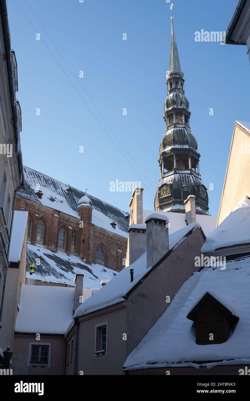 Riga cathedral tower in winter time, snow removing from the roof Stock Photo