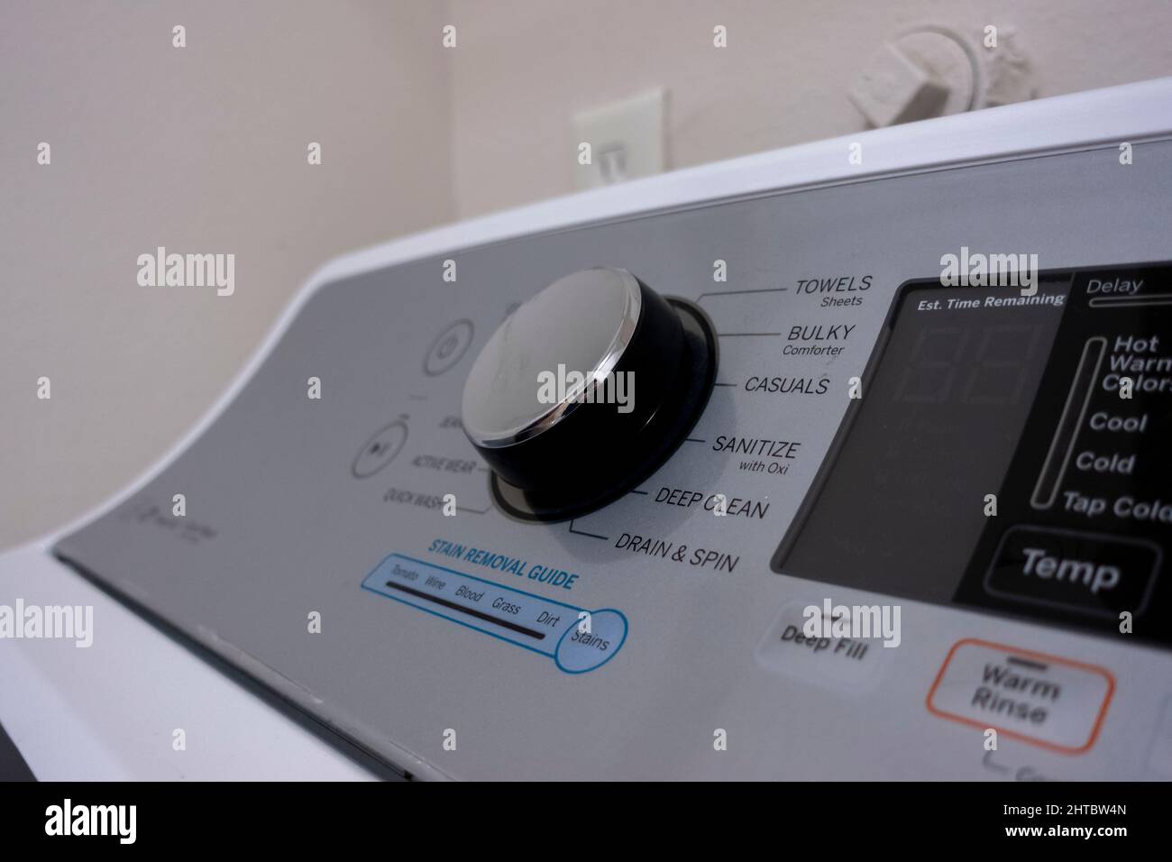 Angled, selective focus on a new, high end clothes washing machine knob control panel, with a variety of wash settings Stock Photo