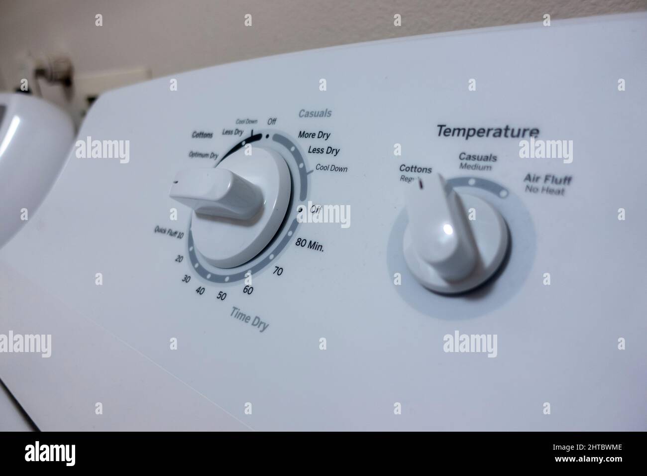 Angled, selective focus on the knob control panel of a white clothes dryer Stock Photo