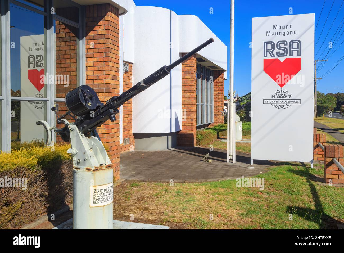 The RSA (Returned and Services Association) building in Mount Maunganui, New Zealand, with a WW2-era Oerlikon 20mm anti-aircraft cannon outside Stock Photo