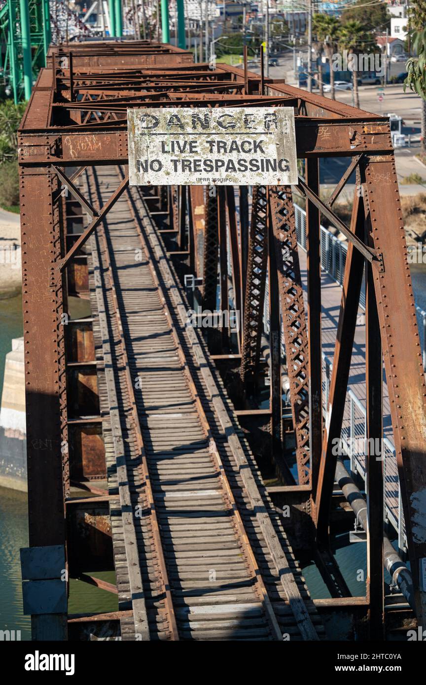 Vertical shot of a rusty railroad with a warning sign Stock Photo - Alamy