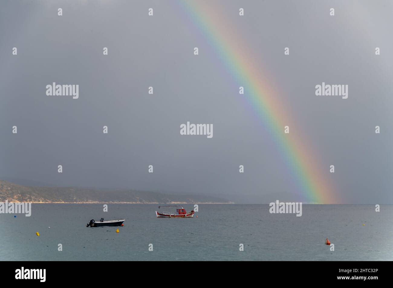 Rainbow and fishing boats at sea. The photo was shot on a cloudy day Stock Photo