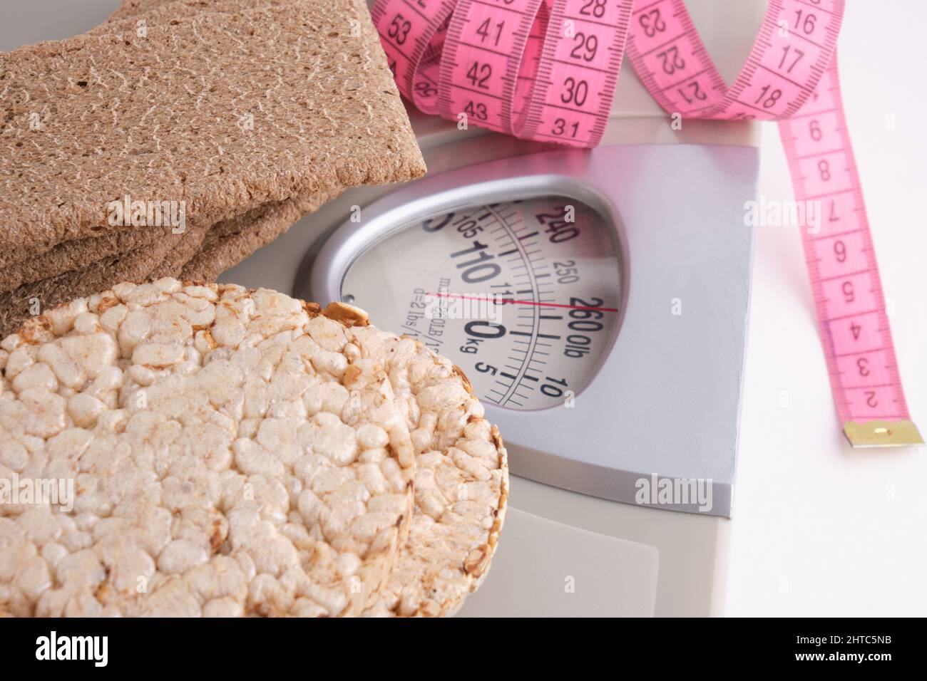 Wheat and rye bread, floor scales and measuring tape on a white