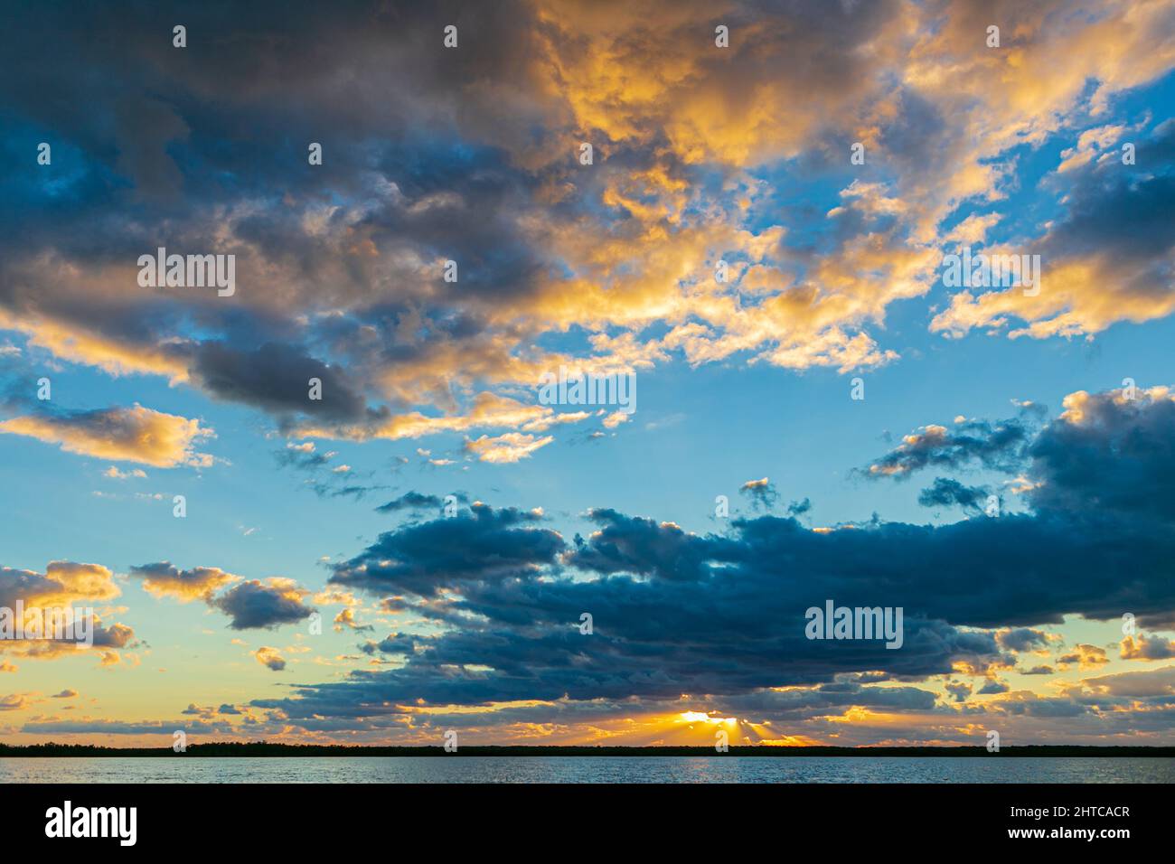 Beautiful sunset sky with fluffy clouds over a sea Stock Photo - Alamy