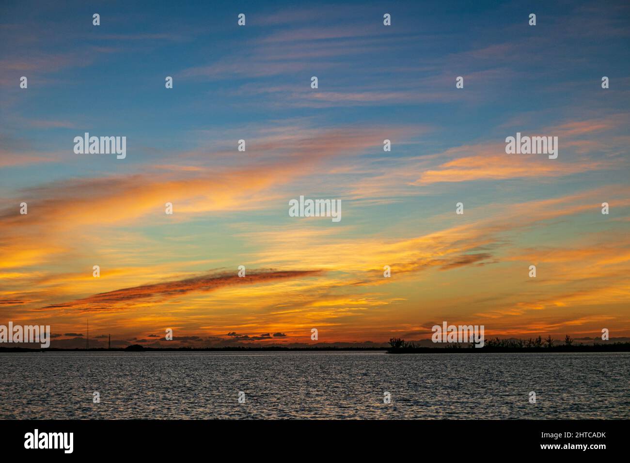 Beautiful sunset sky with fluffy clouds over a sea Stock Photo - Alamy