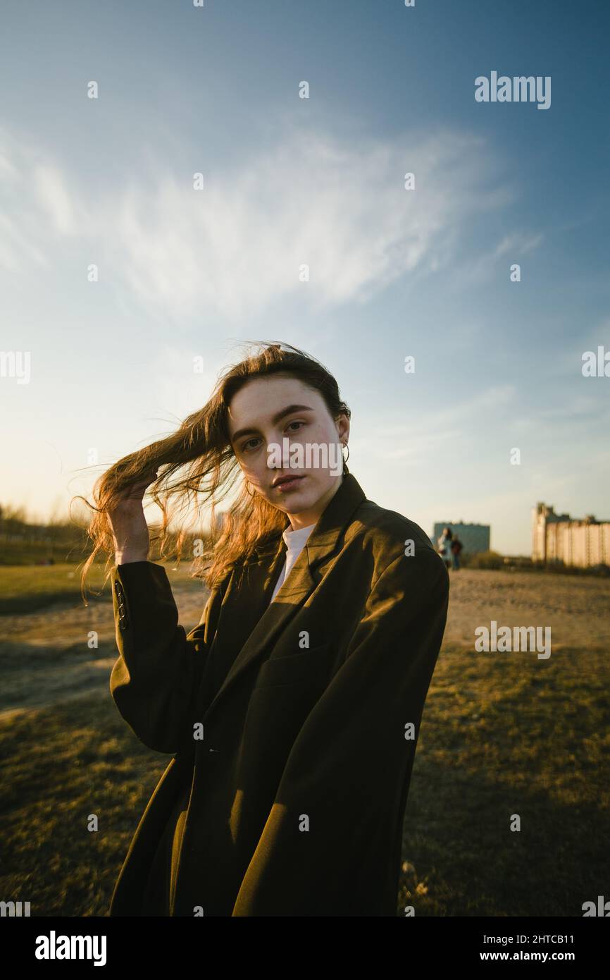 A beautiful girl in a jacket poses for a photo outdoors Stock Photo - Alamy