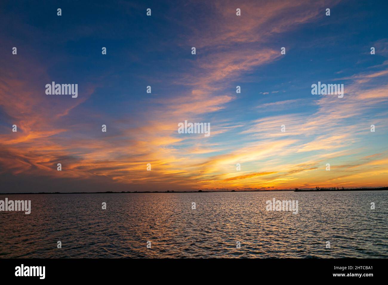 Beautiful sunset sky with fluffy clouds over a sea Stock Photo - Alamy