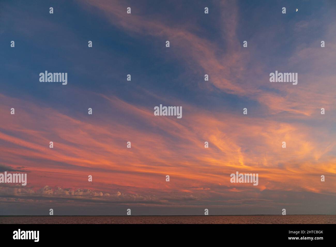 Beautiful sunset sky with fluffy clouds over a sea Stock Photo - Alamy