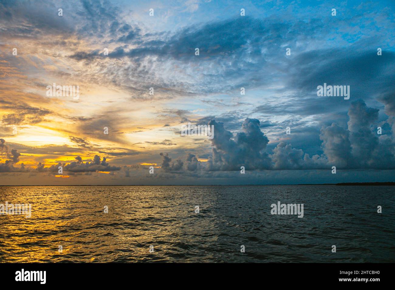 Beautiful sunset sky with fluffy clouds over a sea Stock Photo - Alamy