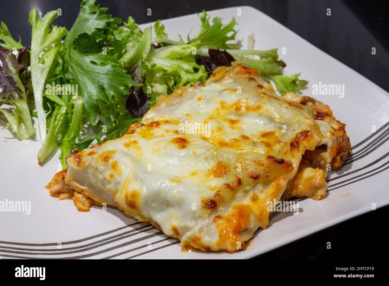 Plated Lasagne with salad Stock Photo