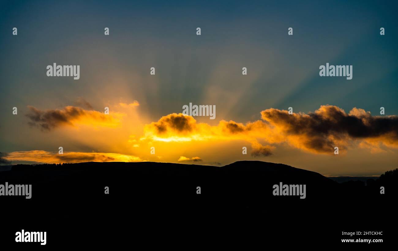Sunbeams at sunset over the Clwydian Range, north Wales Stock Photo