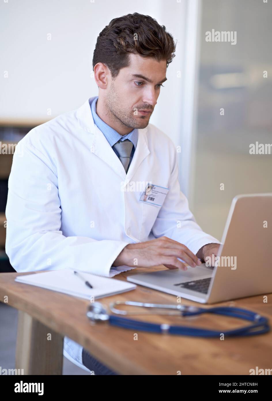 Well informed on every medical procedure. Shot of a young doctor at work on a laptop. Stock Photo