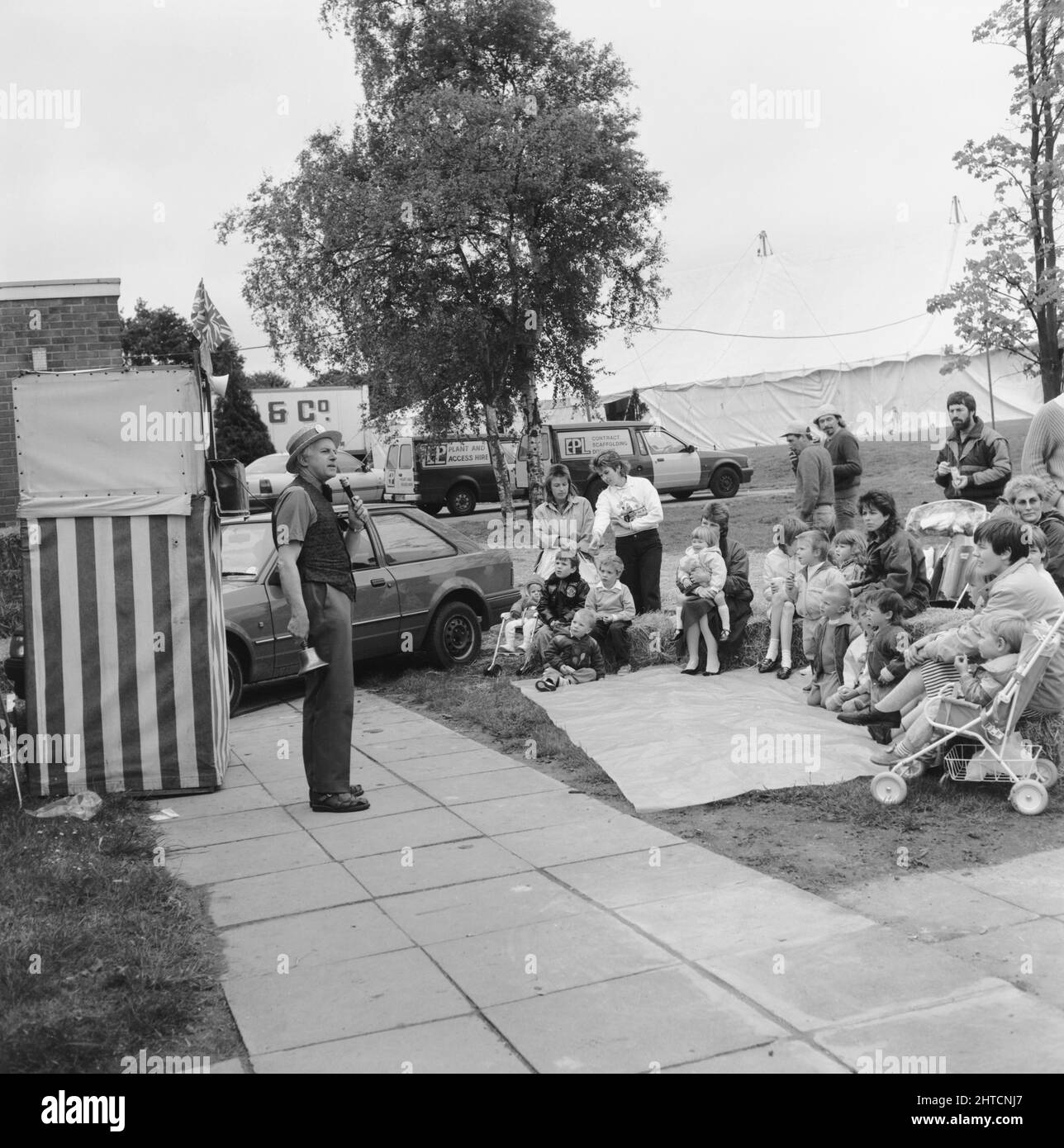 Laing Sports Ground, Rowley Lane, Elstree, Barnet, London, 11/06/1988. Professor Alexander the Punch &amp; Judy man gathering an audience for his next show at the 1988 Family Day at Laing's Sports Ground. Attractions at that year's Family Day included; a parade of vintage cars, helicopter rides, plate smashing, stalls, an 'It's a Knockout' style competition and tennis and six-a-side football tournaments.  The event was opened by John Conteh, former world light heavy weight champion and ended with a barbecue and disco. Stock Photo