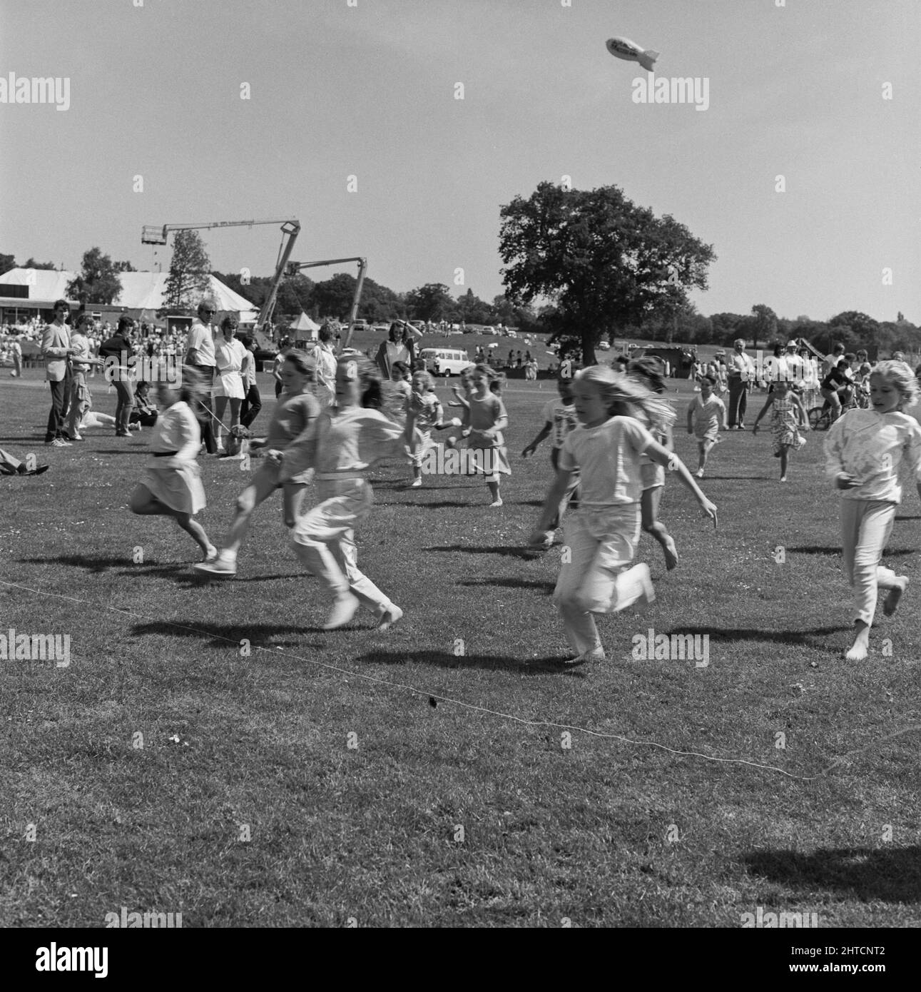 Laing Sports Ground, Rowley Lane, Elstree, Barnet, London, 21/06/1986. Children reaching the finishing line of one of the children's races at the 1986 Family Day at Laing's Sports Ground. Over 2500 people attended the Family Day and raised over &#xa3;700 for that year's designated charity The British Heart Foundation.  Attractions included; guest appearances by the cast of the television programme Grange Hill, a bouncy castle, donkey rides, Punch and Judy shows, Pierre the Clown, children's races, blindfold stunt driving and golf and six-a-side football tournaments. Stock Photo