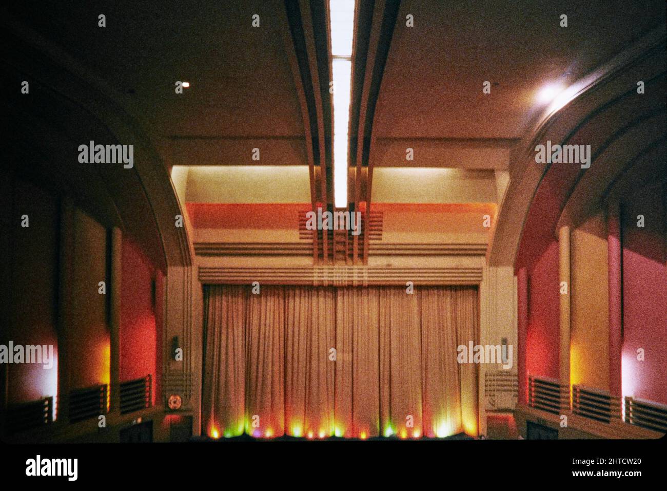 Odeon Cinema, Fortis Green Road, Muswell Hill, Haringey, London, 1974-1999 The central strip laylight and curved ceiling and front of the auditorium in the Odeon Cinema, viewed from the front centre of the circle. The Odeon Cinema opened in 1936. The exterior design of the building was restricted and subdued due to opposition from the church located opposite; the interior was therefore designed to compensate. The auditorium is described as being &quot;the most elaborate interior of any Odeon cinema to survive&quot;. The central laylight, which runs down the centre of the ceiling towards the cu Stock Photo