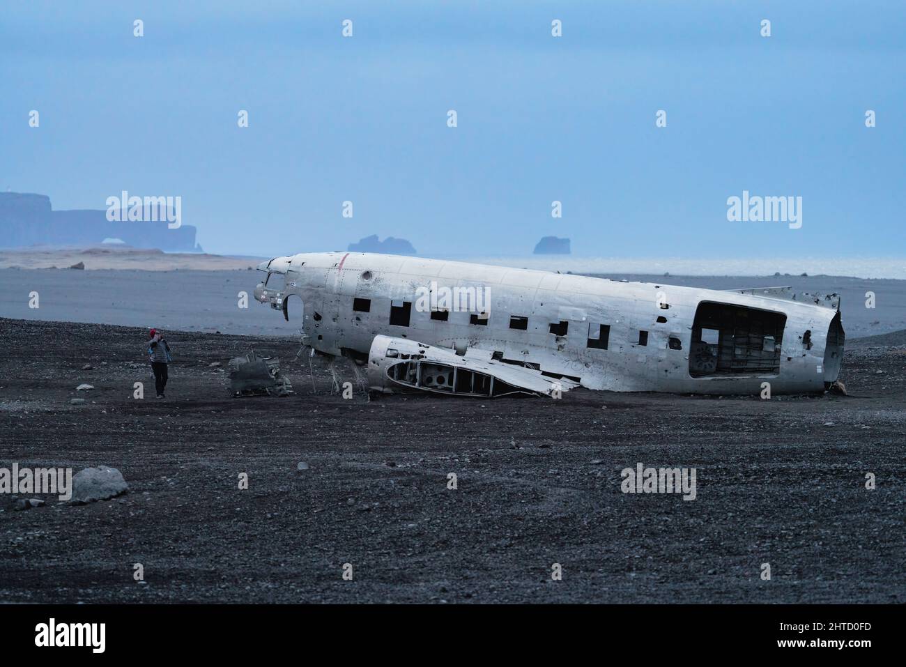 Wreck of an airplane profile and boulders with blurred tourist Stock Photo