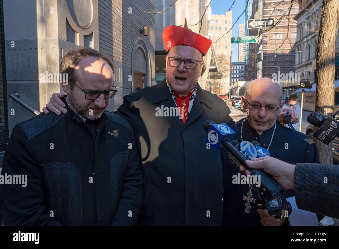 New York, United States. 27th Feb, 2022. Cardinal Timothy Dolan (C) standing with Father Illya (L) and Father Peter (R) speaks to media outside St. George's Church in New York City. His Eminence, Cardinal Timothy Dolan, Archbishop of New York attended mass at St. George's Church, which is a member of the Ukrainian Greek Catholic Church, in solidarity with the Ukrainian people. Credit: SOPA Images Limited/Alamy Live News Stock Photo