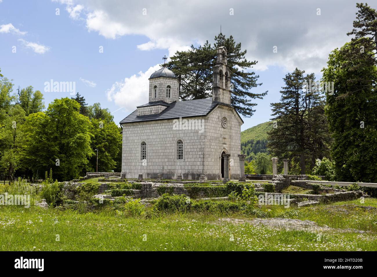 Beautiful view of a green landscape with an old church surrounded by mountains, Virpazar, Montenegro Stock Photo