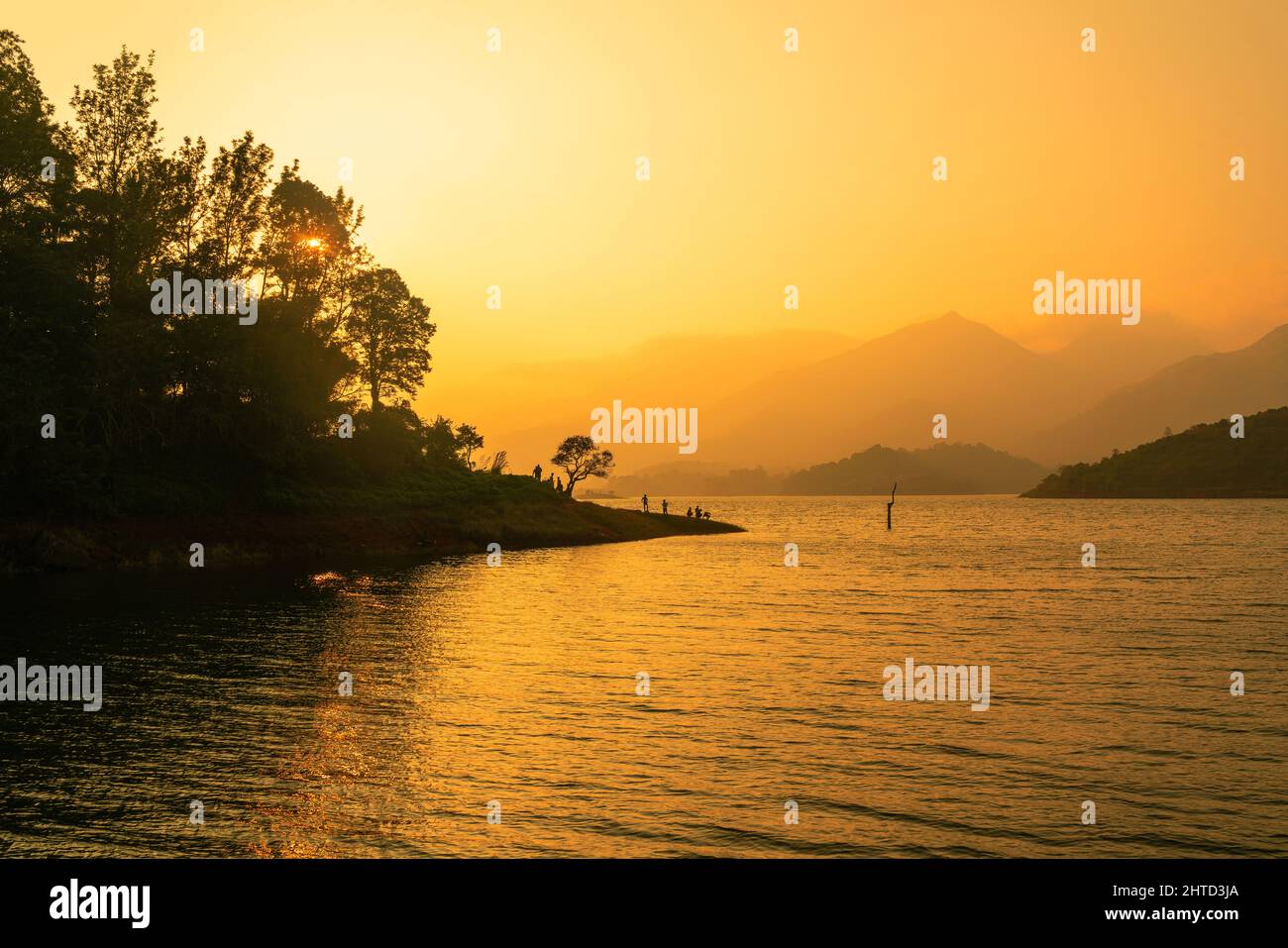 Beautiful sunset view with the peaceful lake and mountains as background, shot from Wayanad Banasura Dam Stock Photo