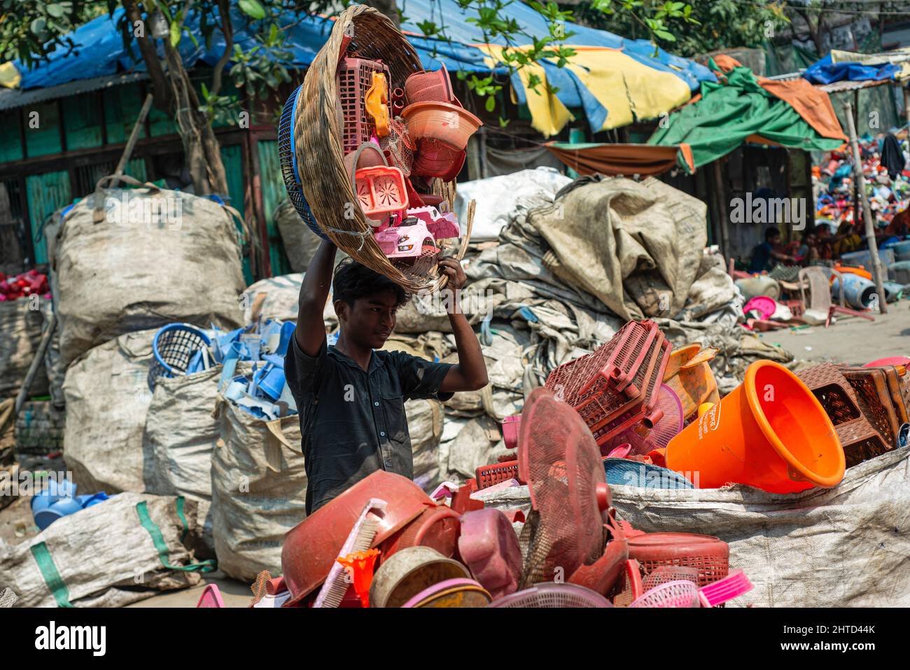 Narayanganj, Bangladesh. 28th Feb, 2022. A worker collects plastics by