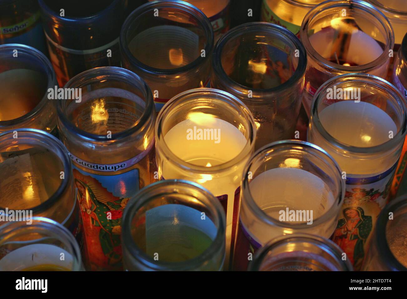 Many jars of religious candles burning with flames Stock Photo Alamy