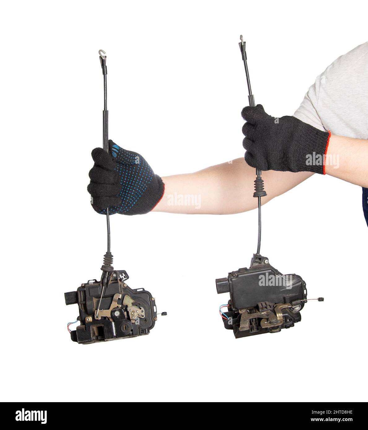An auto electrician holds two electric central car locks in his hands on a white background