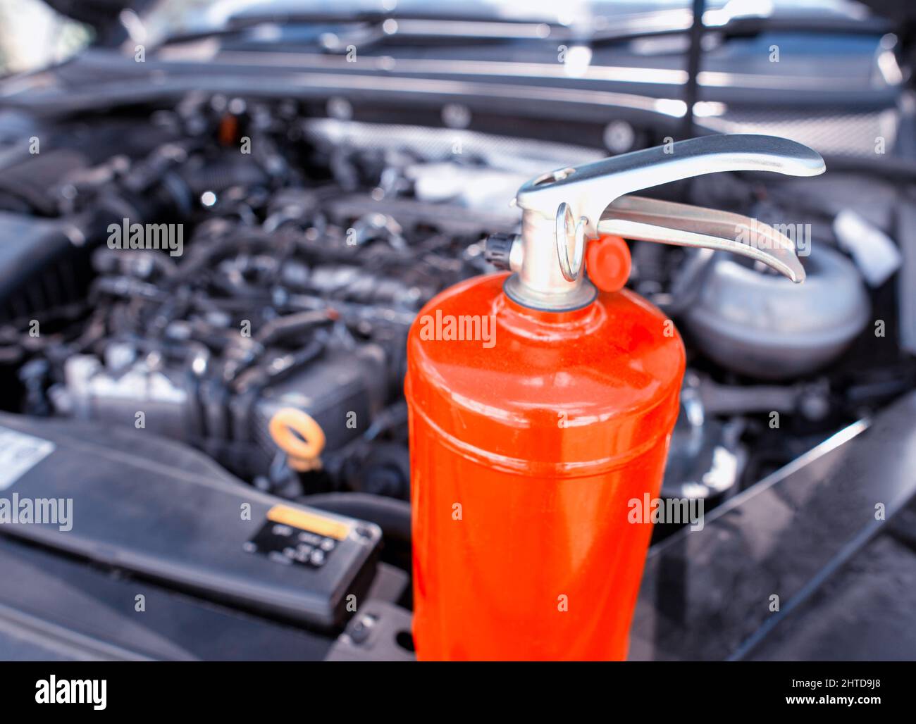 Car fire extinguisher on the background of the car engine