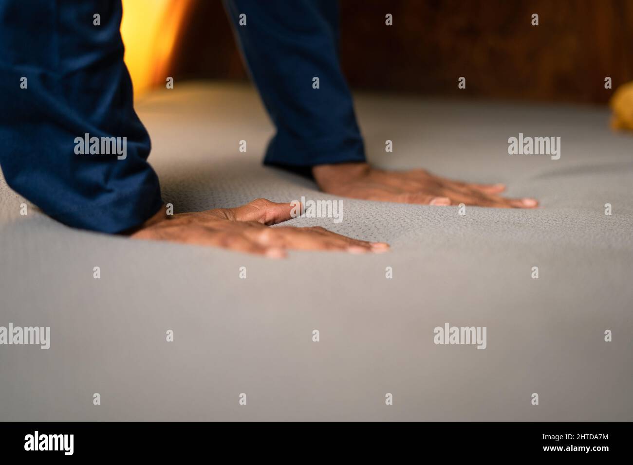 Close up of hands checking bed quality by pressing mattresses at sore before purchase at store Stock Photo