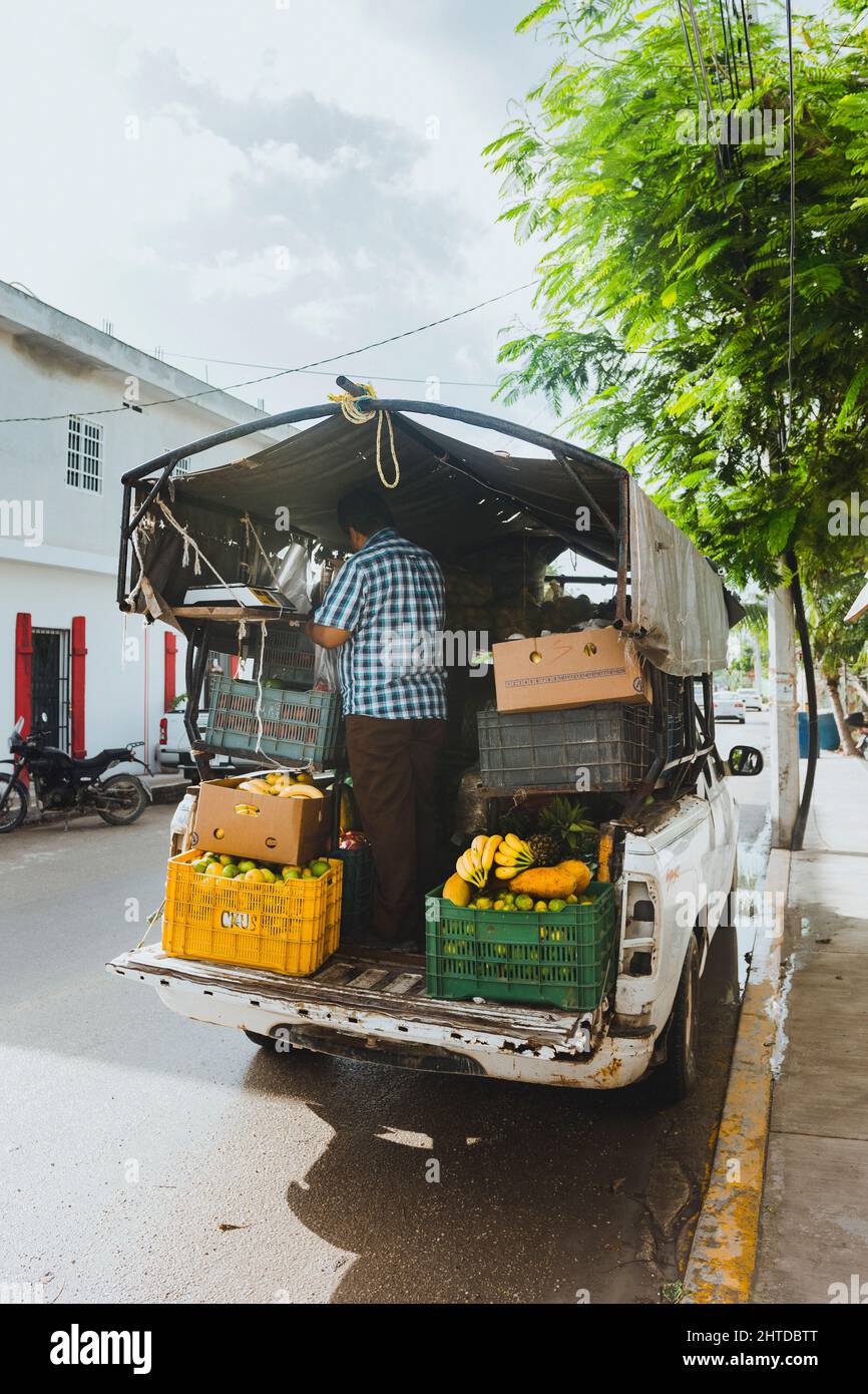 Mexican person worker, with a truck full of fruit Stock Photo