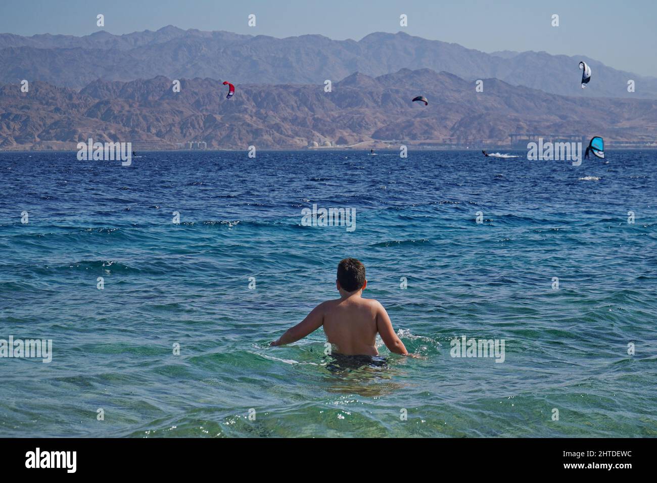 The wind surfing in the sea of Eilat, Israel with the city of Aqaba in Jordan in the background Stock Photo