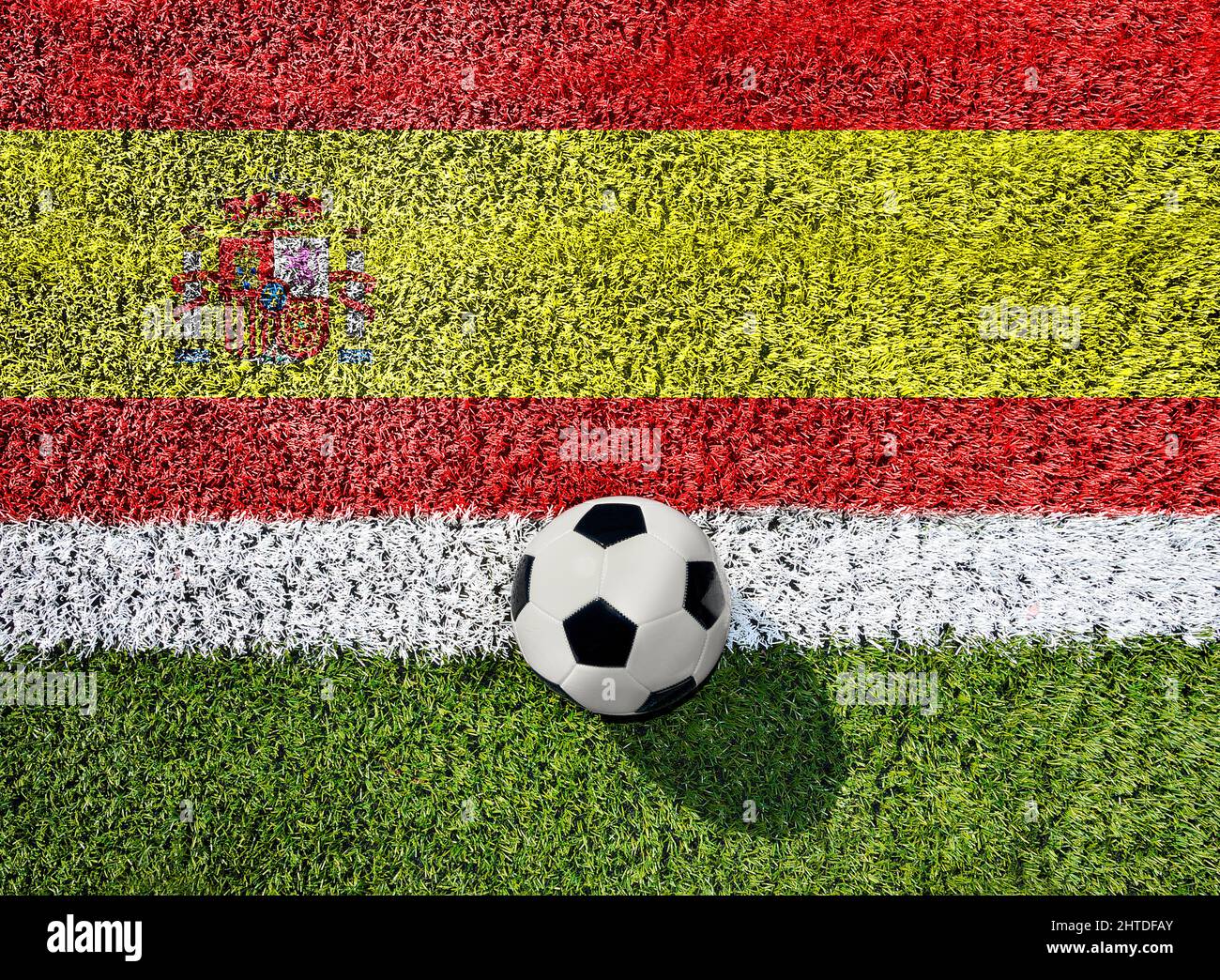 Soccer or football on green grass,on spanish flag background Stock