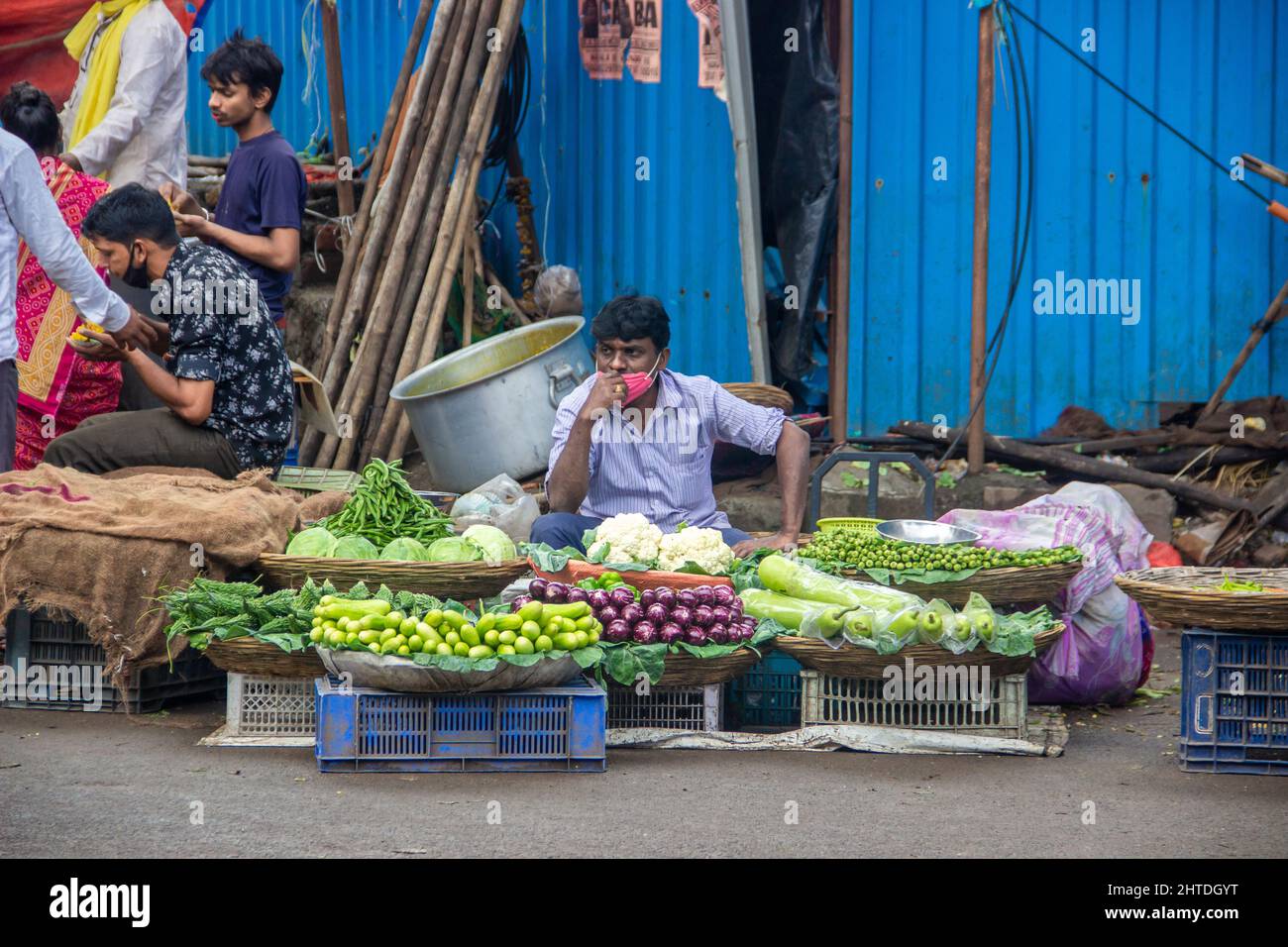An outdoor market with consumers buying fruits and vegetables in India Stock Photo