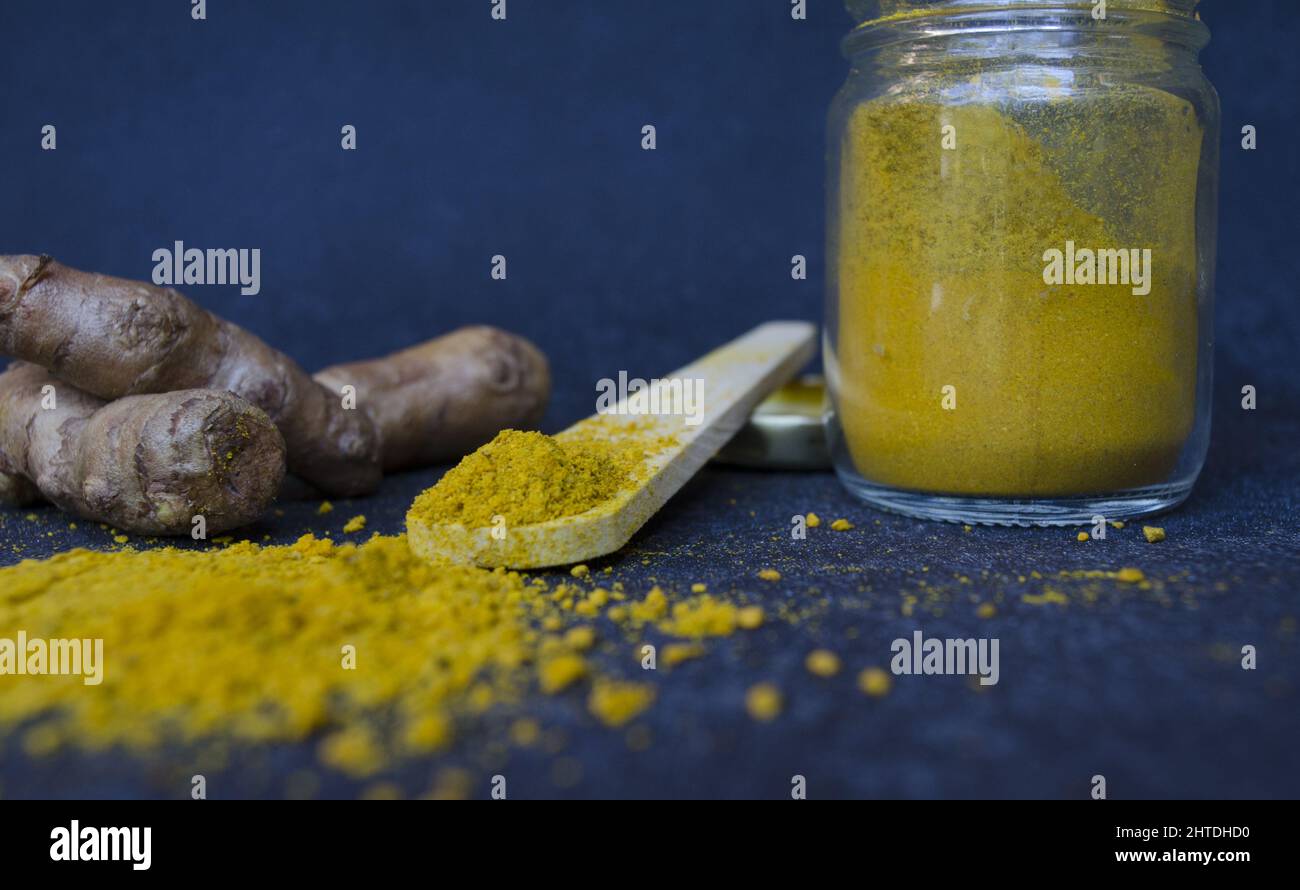 A closeup shot of Indian sulfur with a wooden spoon on a dark blue background Stock Photo